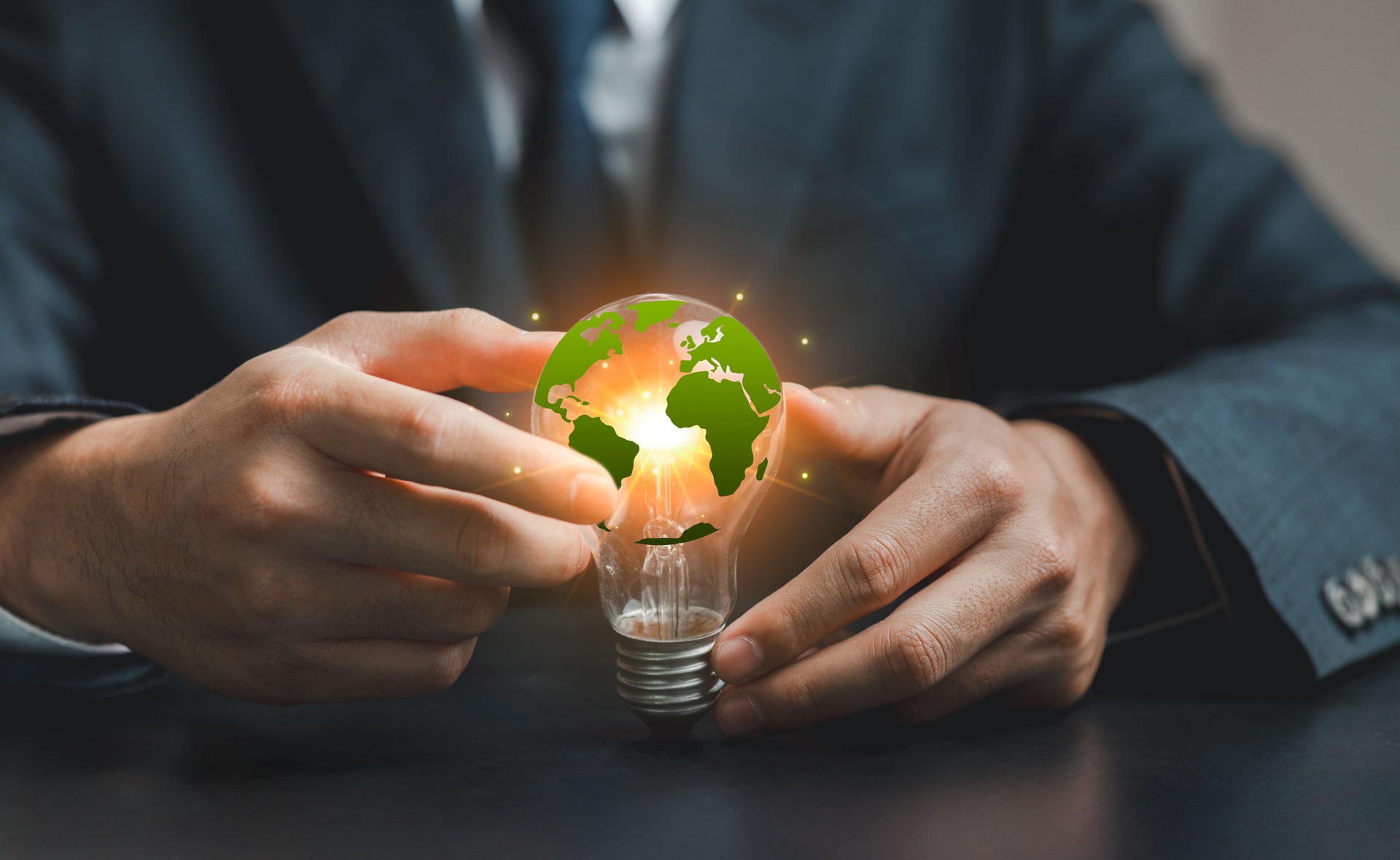 Businessman Holding Light Bulb with Earth Symbolizing Innovation